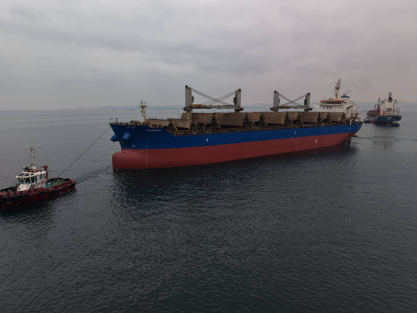 Bulk carrier vessel sailing across open ocean at sunset